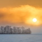 sunset behind snow-covered field